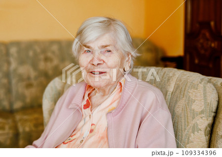 Senior woman of 90 years sitting at home. Portrait of old happy retired lady indoors 109334396