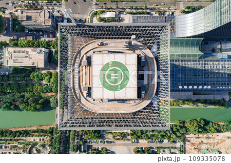Helipad on the rooftop of the modern skyscraper. Glass business offices district. Aerial drone view of helipad on the roof of a skyscraper in downtown. Helipad on the rooftop of the modern skyscraper. Glass business offices district. Aerial drone view of helipad on the roof of a skyscraper in downtown. 109335078
