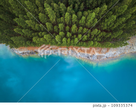 Aerial drone top view of blue pond with pine tree in a rainforest, Phang Nga, Thailand Aerial drone top view of blue pond with pine tree in a rainforest, Phang Nga, Thailand 109335374