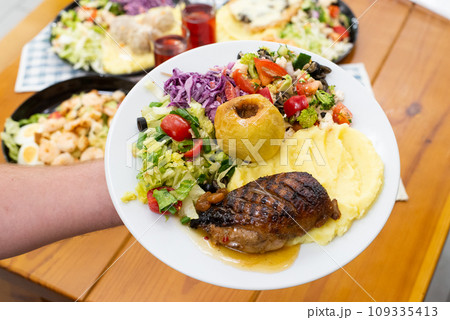 Home made meat dish with salads, in hands dinner time duck and apple Home made meat dish with salads, in hands dinner time duck and apple 109335413