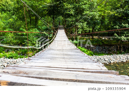 wood flooring of suspension bridge over river 109335904