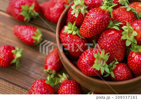 Fresh strawberries in a bowl on wooden table. Strawberry in a Bowl. Top view Fresh strawberries in a bowl on wooden table. Strawberry in a Bowl. Top view 109337181