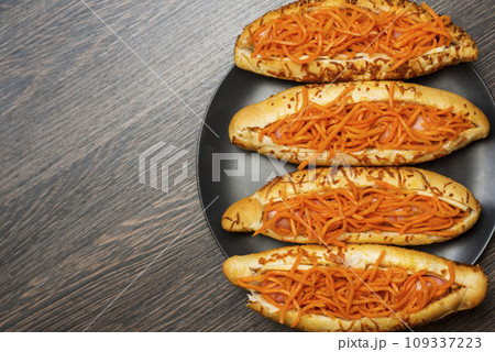 Tasty hot dogs on a black plate on a wooden background. Top view, copy space Tasty hot dogs on a black plate on a wooden background. Top view, copy space 109337223
