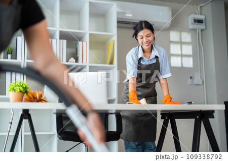 Asian woman cleaning in work room at home. Young woman housekeeper cleaner use a cloth to wipe equipment for working. concept housekeeping housework cleaning Asian woman cleaning in work room at home. Young woman housekeeper cleaner use a cloth to wipe equipment for working. concept housekeeping housework cleaning 109338792