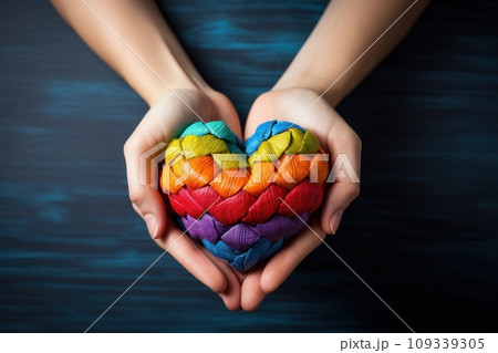 Hands hold heart in the colors of rainbow on light blue background. LGBT concept. Generative AI 109339305