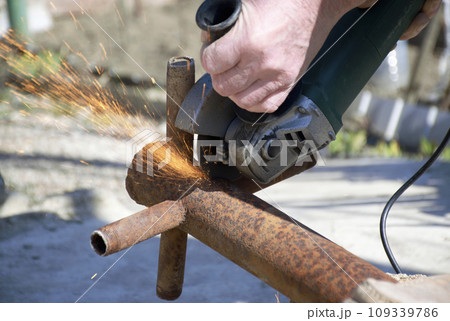 male hands hold a working power tool for cutting metal 109339786