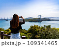鷲羽山展望台から瀬戸大橋の風景を写真に撮る女性の後ろ姿 109341465