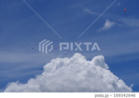 青空に浮かぶ白い雲と空に舞うパラグライダー 青空に浮かぶ白い雲と空に舞うパラグライダー 109342646
