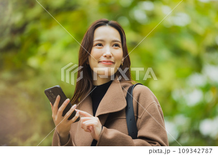 屋外を歩くコートの女性　 109342787