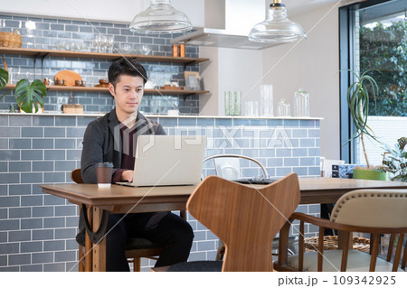 お洒落なカフェでパソコンを使うビジネスカジュアルの男性　右にコピースペースあり	 109342925