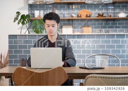お洒落なカフェでパソコンを使うビジネスカジュアルの男性　右にコピースペースあり	 109342926