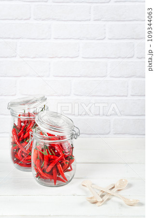 red hot chili peppers on a white wooden table red hot chili peppers on a white wooden table 109344063