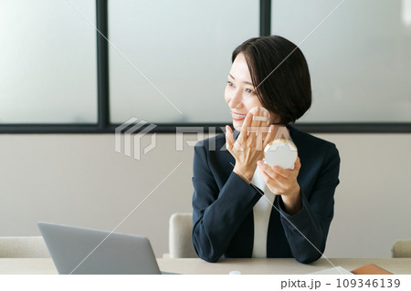 メイク直しをするオフィスの女性 メイク直しをするオフィスの女性 109346139