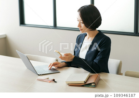 メイク直しをするオフィスの女性 メイク直しをするオフィスの女性 109346187