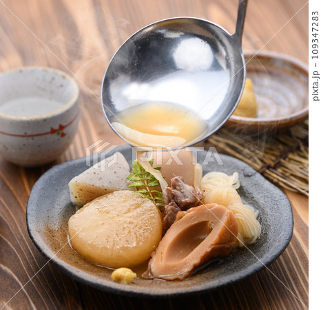 小皿に取り分けたおでんにつゆをかける 109347283