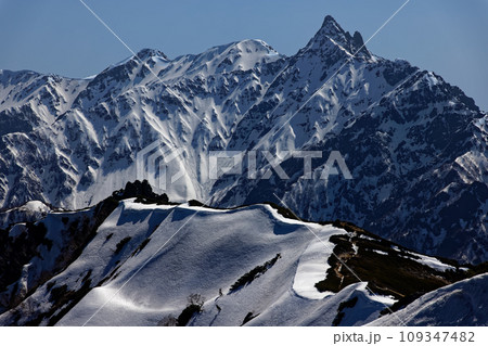 北アルプス・燕岳稜線から見る午後の光に浮かぶ残雪の槍ヶ岳 109347482
