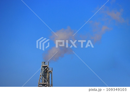 Pipe with white smoke against a blue sky. 109349103