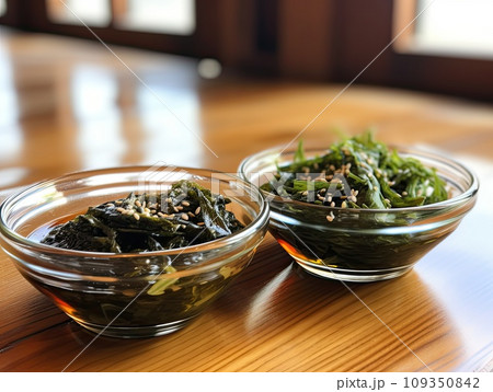 Japanese raw vegan organic delicious and tasty marinated chuka wakame salad and seaweed nori salad dishes in glass bowls on a wooden table 109350842