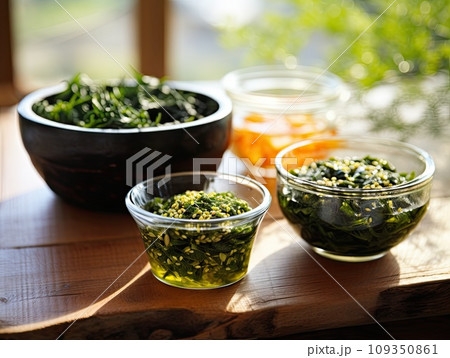 Japanese raw vegan organic delicious and tasty marinated chuka wakame salad and seaweed nori salad dishes in glass bowls on a wooden table Japanese raw vegan organic delicious and tasty marinated chuka wakame salad and seaweed nori salad dishes in glass bowls on a wooden table 109350861