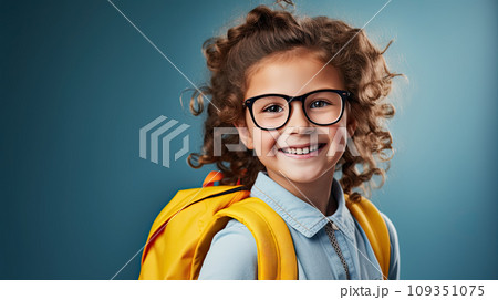 Handsome 7yo little girl in glasses is surprised, inspired, copy space, isolated on blue background 109351075