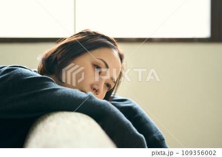 ソファーに横たわる女性 109356002