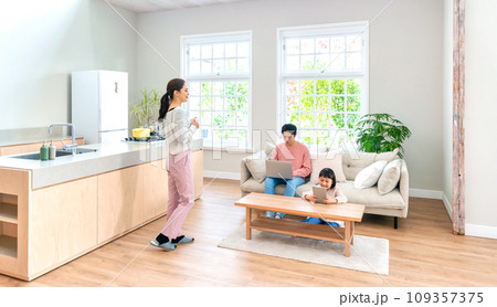 パパ、ママ、子供、リビングでそれぞれ別のことをしているシーン 109357375