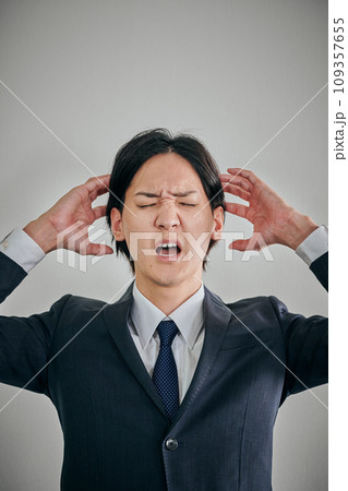 頭を抱えてショックを受ける若い男性会社員 109357655