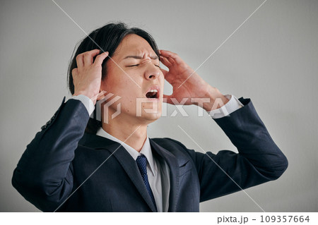 頭を抱えてショックを受ける若い男性会社員 109357664