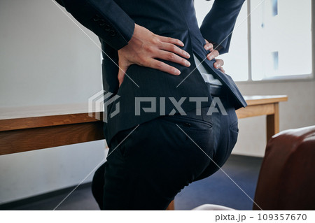 腰が痛くて手で押さえる若い男性会社員 109357670