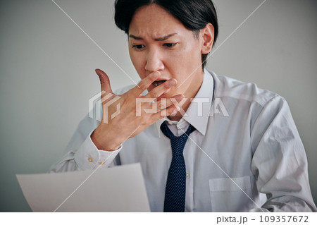 資料を見て驚きの表情をする若い男性会社員 資料を見て驚きの表情をする若い男性会社員 109357672