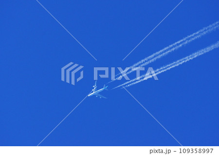青空を飛行するジャンボジェット機と飛行機雲 109358997