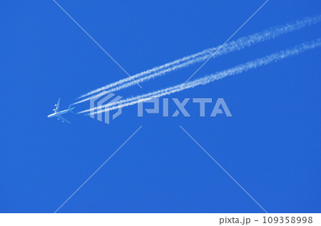 青空を飛行するジャンボジェット機と飛行機雲 109358998