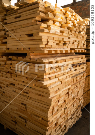 Stacked wooden planks. Hardware store or construction site. Wood for house construction. Building material. Wood warehouse. Wood industry. 109359108