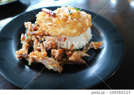 rice topped with sunny side up egg and fried pork 109360125