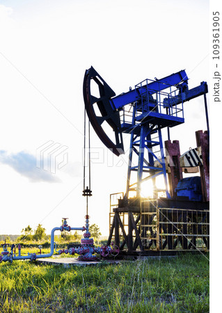 An active oil rig operating at sunrise or sunset. Resource extraction, oil crisis. 109361905