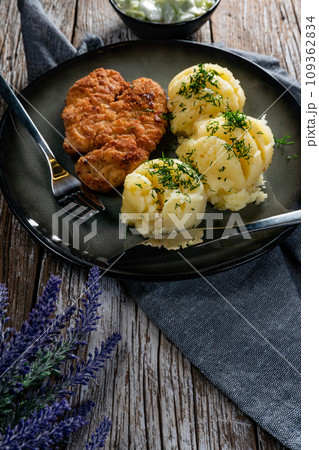 Pork chop served with mashed potatoes and cucumber salad. Pork chop served with mashed potatoes and cucumber salad. 109362834