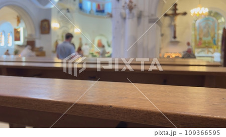 Believers in a Catholic church behind the benches. 109366595