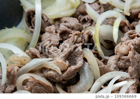 牛肉(黒毛和牛モモ薄切り)と玉ねぎをフライパンで炒める調理シーン。 109366669