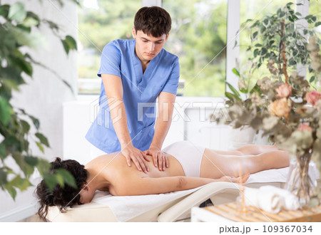 Massage therapist guy is massaging woman in spa complex 109367034