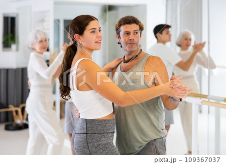 Active sportive men and women enjoying of partner dance in dance studio 109367037