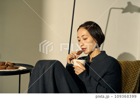 夕暮れ時、ソファーでくつろぐ女性 夕暮れ時、ソファーでくつろぐ女性 109368399