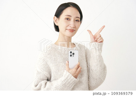 スマホを持ってチェックサインをするミドルエイジの女性 白背景 スマホを持ってチェックサインをするミドルエイジの女性 白背景 109369379
