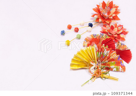 金と赤の和柄模様の扇子と柳餅と花のある和風イメージ素材 109371344