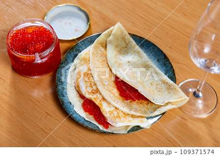 Tasty russian pancakes with red caviar at plate closeup 109371574