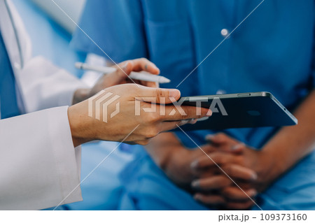 Doctor telling to patient woman the results of her medical tests. Doctor showing medical records to cancer patient in hospital ward. Senior doctor explaint the side effects of the intervention. Doctor telling to patient woman the results of her medical tests. Doctor showing medical records to cancer patient in hospital ward. Senior doctor explaint the side effects of the intervention. 109373160