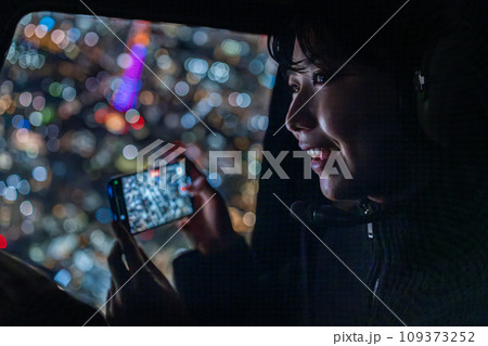東京夜景をIPHONEで撮影する若い女性 東京夜景をIPHONEで撮影する若い女性 109373252