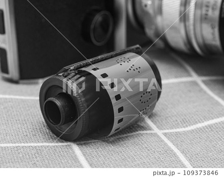 classic 135 film cassette with retro camera background classic 135 film cassette with retro camera background 109373846