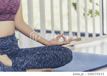Yoga fitness lifestyle healthy woman relaxation doing a meditation. Yoga meditate outdoor with zen on sitting position. Yoga woman workout in sportswear sit on yoga mat home fitness workout exercise Yoga fitness lifestyle healthy woman relaxation doing a meditation. Yoga meditate outdoor with zen on sitting position. Yoga woman workout in sportswear sit on yoga mat home fitness workout exercise 109374525