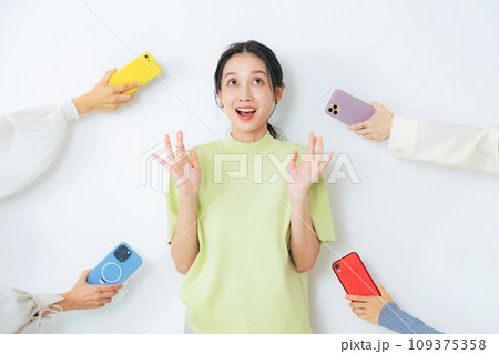 スマホを差し出されてびっくりする女性 109375358