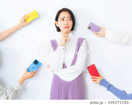 スマホを差し出されて悩むミドル女性 スマホを差し出されて悩むミドル女性 109375390